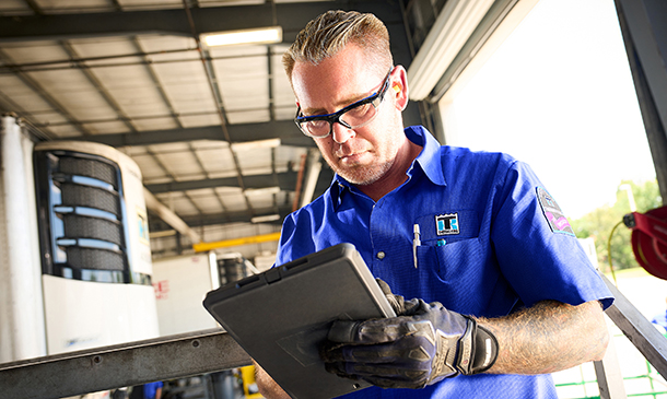 Service technician typing maintenance notes on a tablet